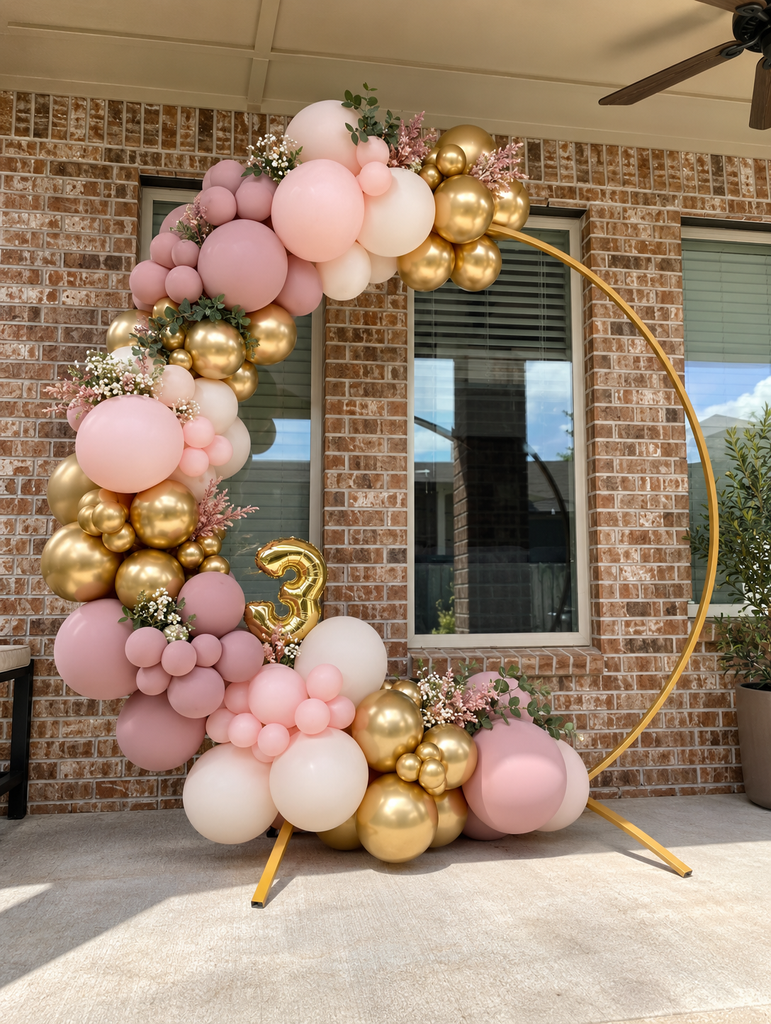 Illustrated round gold frame with blush, ivory and gold balloon clusters