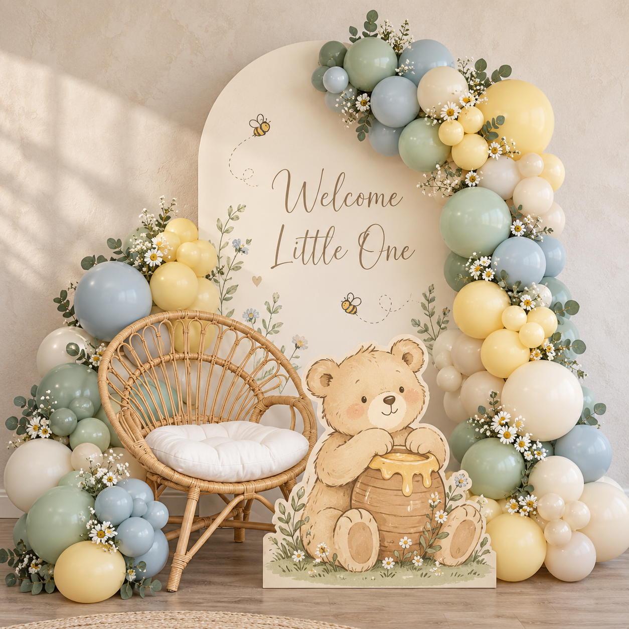 Illustrated welcome backdrop with sage, blue, cream and yellow balloons, a rattan chair and bear illustration
